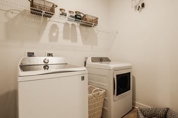 Laundry room with washer and dryer with shelves